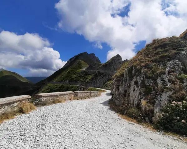 Strade panoramiche Liguria in moto: un percorso tortuoso tra montagne verdi e cielo azzurro, ideale per un'avventura su due ruote.