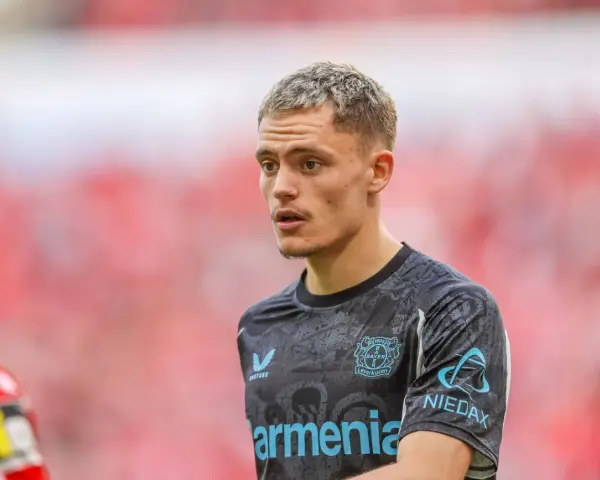 Młody piłkarz Florian Wirtz w koszulce Bayer Leverkusen, skupiony na boisku.