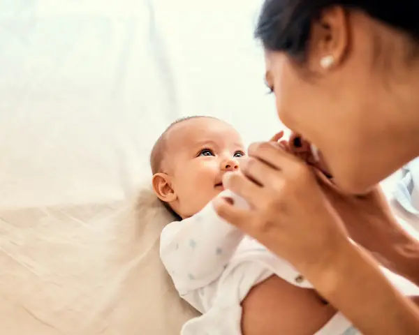 Mama czule głaszcze niemowlę, które wpatruje się w nią z zaciekawieniem. Choć ma dopiero kilka miesięcy, już widać, że to **3 letnie dziecko nie reaguje na imię**, co martwi rodziców.