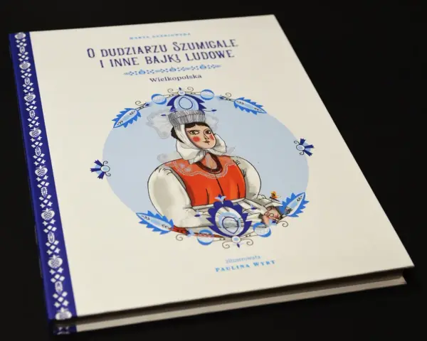 Okładka książki "O dudziarzu szumigale i inne bajki ludowe" z Wielkopolski. Ilustracja przedstawia kobietę w tradycyjnym stroju, jakby opowiadającą historie z tego słownika polskiej bajki ludowej.