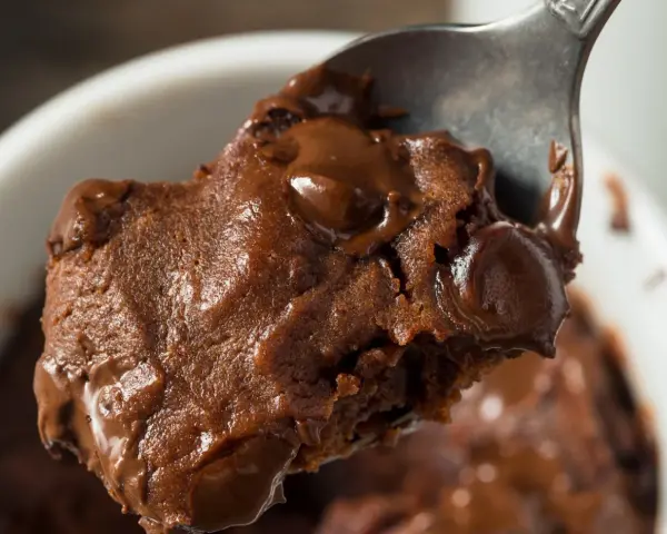 Łyżka z porcją pysznej, pieczonej owsianki brownie z roztopioną czekoladą.