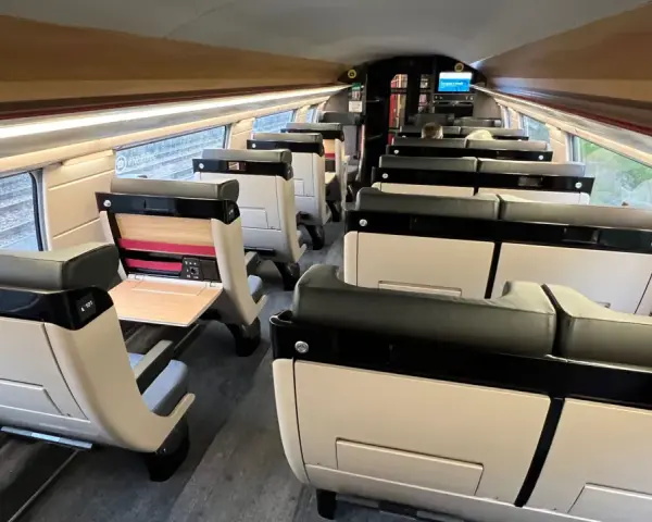 Interior of a modern train carriage, likely the Paris to Bilbao train, with rows of comfortable, beige and black seats.