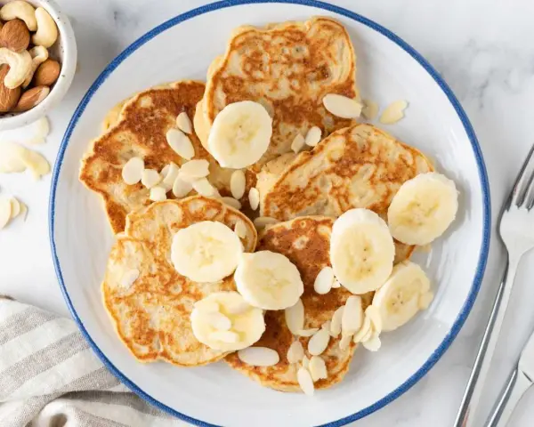 Deliciosas tortitas de plátano, cubiertas con rodajas de plátano y almendras laminadas. Un desayuno perfecto.