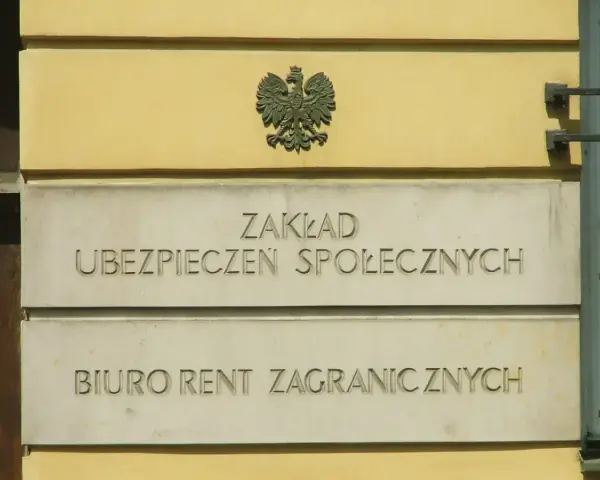 Tablica z napisem "Zakład Ubezpieczeń Społecznych" i godłem Polski.