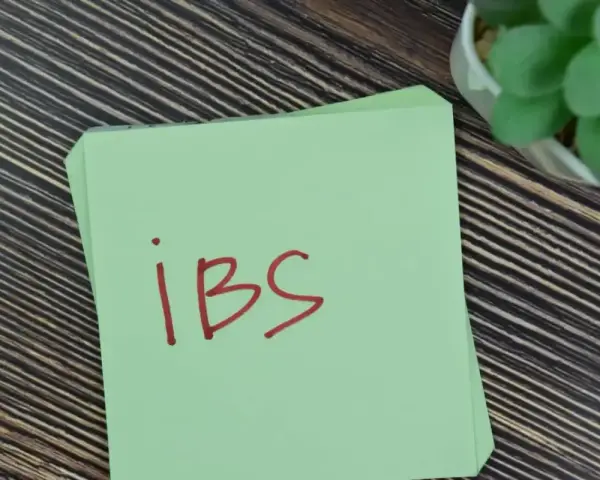 Na zielonej kartce napisano "IBS". Może to przypomnienie o lekach, takich jak Duspatalin, które pomagają w łagodzeniu objawów zespołu jelita drażliwego.