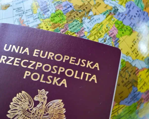 Polski paszport na tle globusa z zaznaczoną Europą.