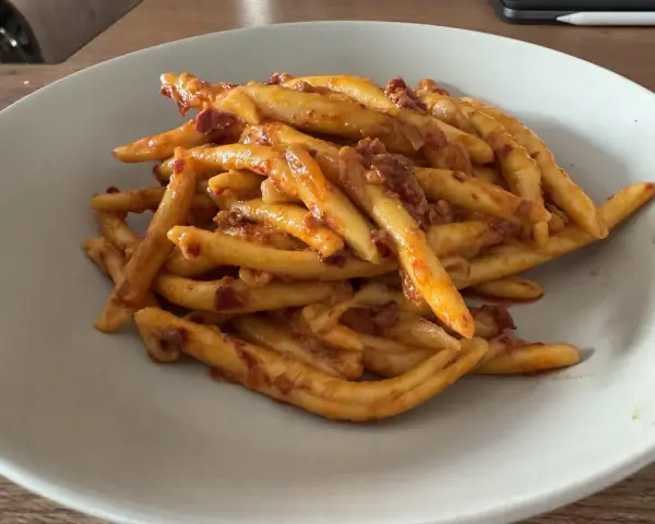 Makaron maccheroni al ferretto z sosem pomidorowym i kawałkami mięsa. Idealny na szybki obiad.