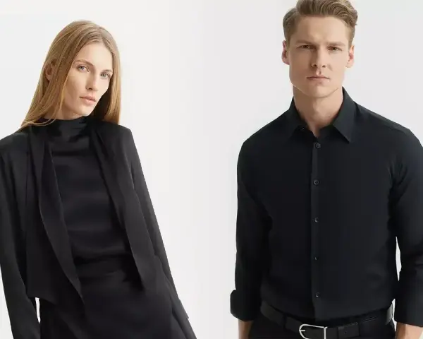 Elegancka kobieta w czarnej stylizacji i mężczyzna w czarnej koszuli. Jakie spodnie do czarnej koszuli? Klasyka zawsze w modzie.