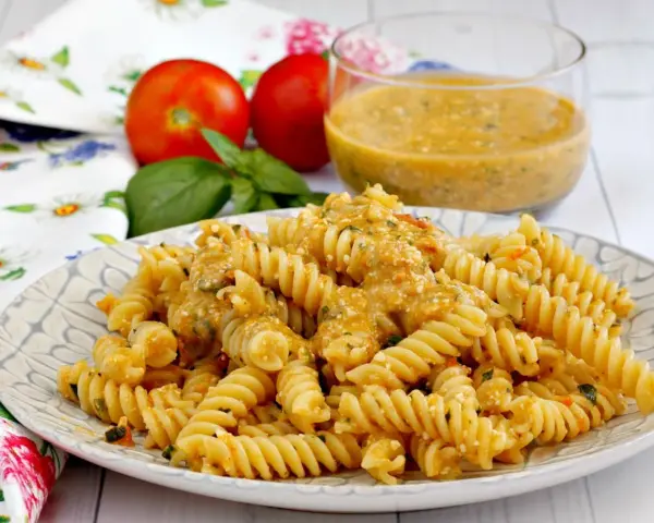 Fusilli conditi con una cremosa salsa di ricotta e pomodorini, guarniti con basilico fresco.