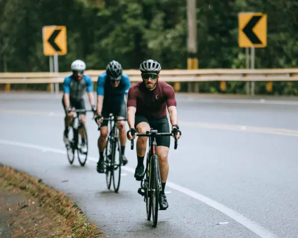 Cyclists on a wet road, navigating curves, embodying the stress recovery adaptation cycle.