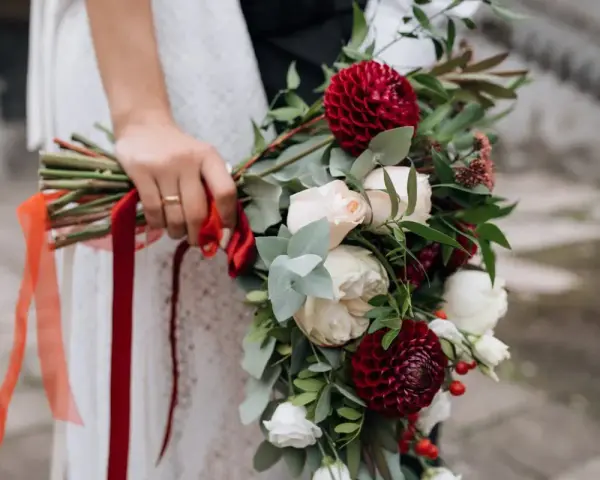 Elegancki bukiet z czerwonych i białych kwiatów, ozdobiony wstążkami, idealny jako kwiaty na ślub w prezencie.