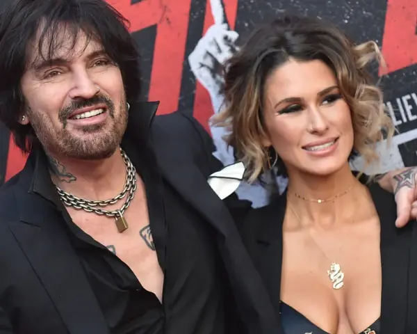 Tommy Lee i jego żona, Brittany Furlan, uśmiechają się do aparatu na czerwonym dywanie.