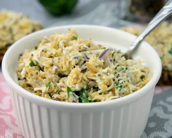 Pyszna pasta z makreli z cebulką i natką pietruszki, podana w białej miseczce, gotowa do smarowania.