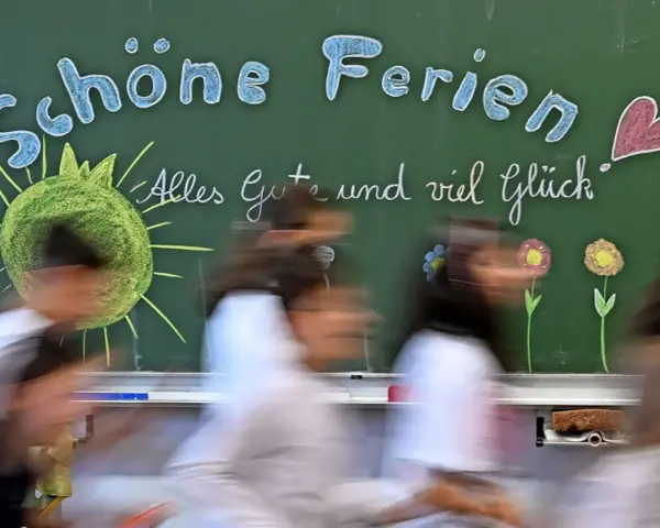 Schöne Ferien! Kinder in Schleswig-Holstein freuen sich auf die Herbstferien. Tafel mit Sonne, Herz und Blumen.