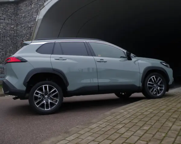 Szary Toyota Corolla Cross hybrydowa stoi na tle tunelu.