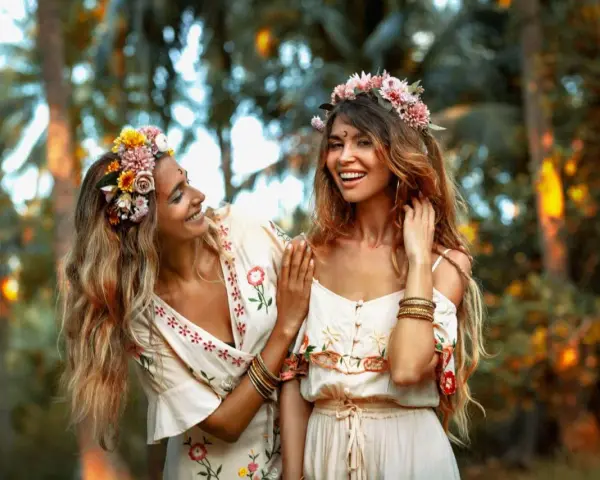 Dos amigas sonríen, adornadas con coronas de flores. Su vínculo es tan fuerte como una **piedra de la amistad**.