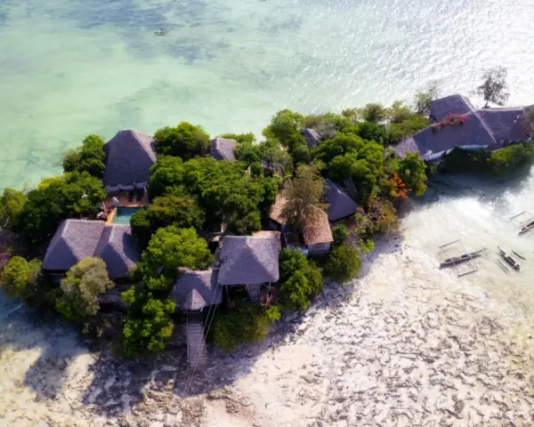 Rajska wyspa z chatkami i basenem, otoczona turkusową wodą. Idealne zanzibar atrakcje dla szukających spokoju.