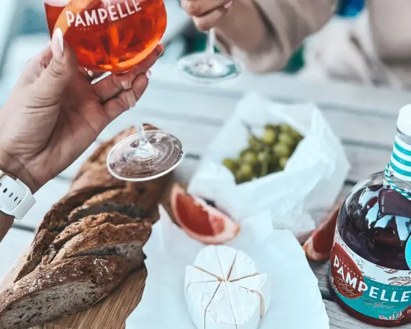 Aperitif co to? Kieliszek Pamplelle Ruby Rose, bagietka, ser brie i winogrona tworzą idealny zestaw na letnie popołudnie.