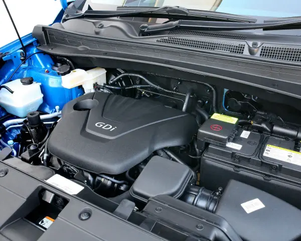 Silnik GDI w Kia Sportage (2015) z widocznym akumulatorem i płynami.