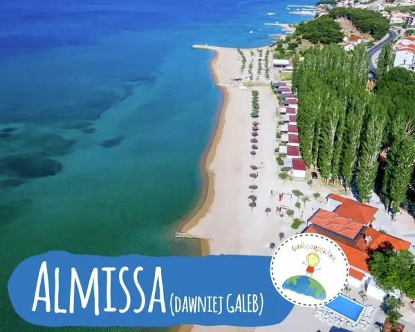 Widok z lotu ptaka na plażę i kemping Almissa (dawniej Galeb) w Chorwacji. Turkusowe morze, piaszczysta plaża, rzędy domków i wysokie drzewa.