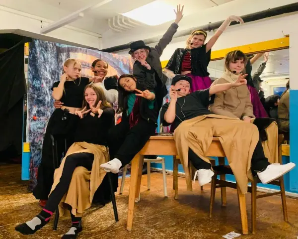 Des jeunes acteurs en costumes colorés, prêts pour une pièce de théâtre. Une joyeuse colonie de vacances artistique !