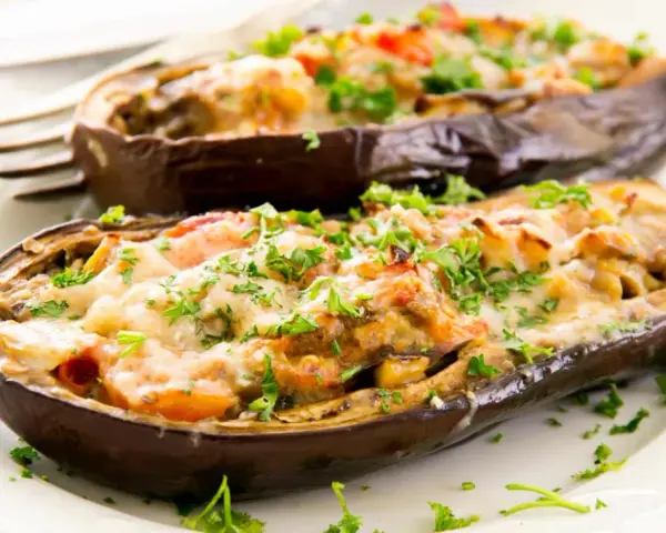 Berenjenas rellenas de carne picada, gratinadas con queso y perejil fresco. Un plato casero y delicioso.