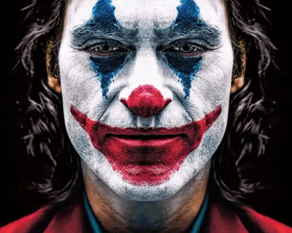 Intensywny joker makijaż z niebieskimi łzami i czerwoną, uśmiechniętą twarzą.