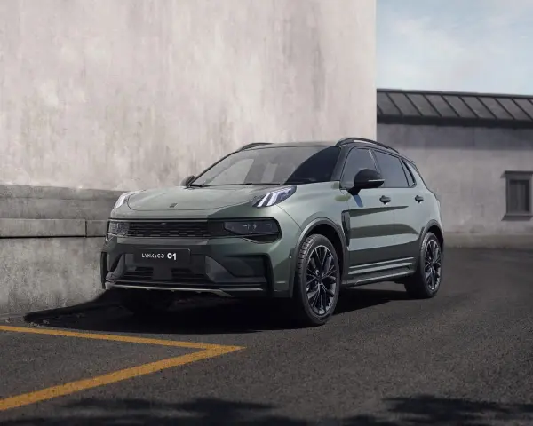 Nowoczesny, zielony SUV Lynk & Co 01 zaparkowany przy betonowej ścianie.