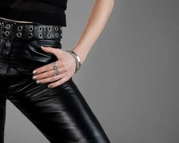 Pantaloni in ecopelle neri, con cintura e accessori metallici. Scopri come lavare pantaloni in ecopelle per mantenerli al meglio.