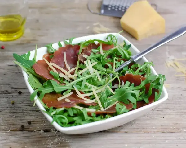 Insalata fresca con bresaola rucola e grana, condita con olio d'oliva e pepe.