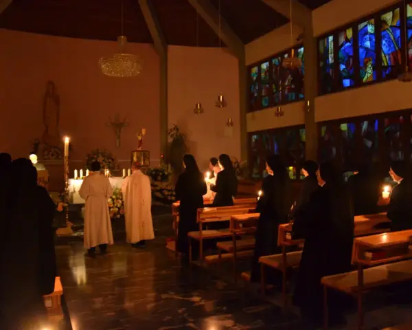 Schwestern in einem Gottesdienst, Kerzenlicht erhellt die Szene. Markus 16.