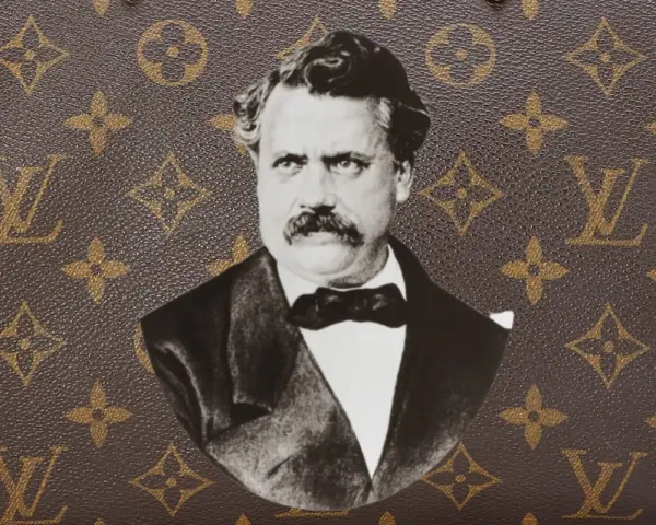 Ritratto in bianco e nero di Louis Vuitton, con il suo iconico monogramma sullo sfondo.