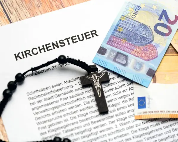 Kirchensteuer-Dokument mit Kreuz und Euro-Scheinen. Informationen zur Frage: Kirchenaustritt ab wann wirksam.