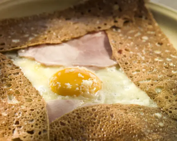 Crêpe bretonne garnie d'un œuf au plat, de jambon et de fromage. Un délice de crêpes françaises.
