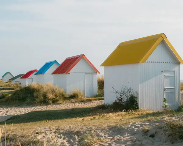 Cabanes de plage colorées à Gouville-sur-Mer : découvrez les activités nautiques et les promenades sur le sable.