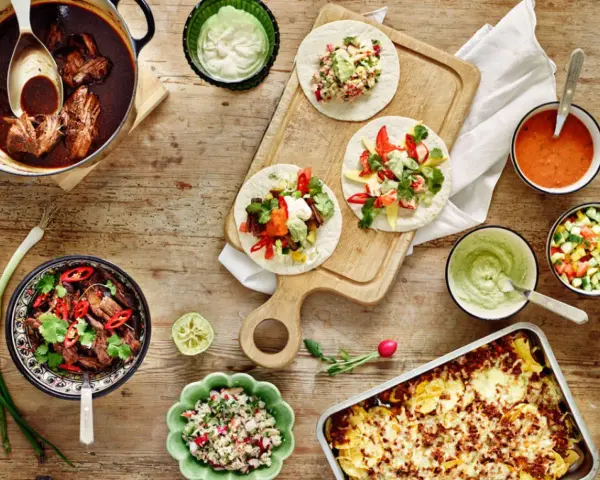 En härlig dukning med tacos, gryta med kött, salsa och guacamole. Perfekt för en mysig kväll med vin till tacos.