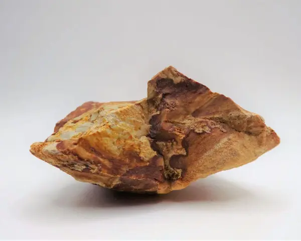 Fragmento de jaspe con vetas rojizas y ocres, mostrando sus propiedades terrosas y su belleza natural.