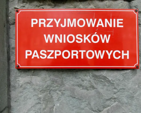 Czerwona tablica informuje o przyjmowaniu wniosków paszportowych. Czy żona może odebrać paszport męża? Sprawdź w urzędzie.