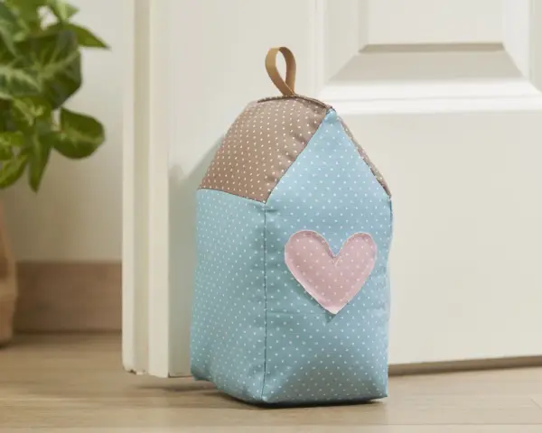 Un cale porte en tissu gratuit en forme de maison, avec un cœur rose. Parfait pour un **patron cale porte en tissu gratuit**.