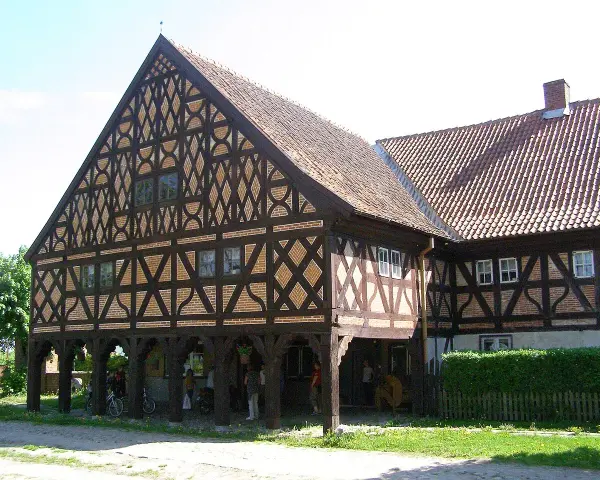 Piękny dom podcieniowy z charakterystyczną, zdobioną szachulcową fasadą i ceramicznym dachem.