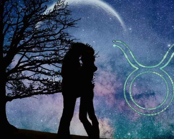 Para zakochanych całuje się pod drzewem na tle nocnego nieba z księżycem i symbolem byk znak zodiaku.