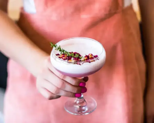 Różowy drink z płatkami róży i gałązką tymianku. To idealna alternatywa dla gin z tonikiem, gdy masz ochotę na gin z różową lemoniadą.