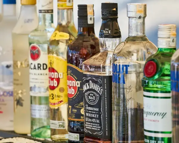 Szereg butelek alkoholi: wódka, rum, whisky, gin. Idealne do shotów warstwowych kontra shoty mieszane.