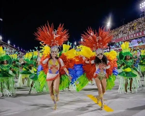 Tancerki w barwnych strojach z piórami na tle tłumu na **Rio de Janeiro karnawał**.