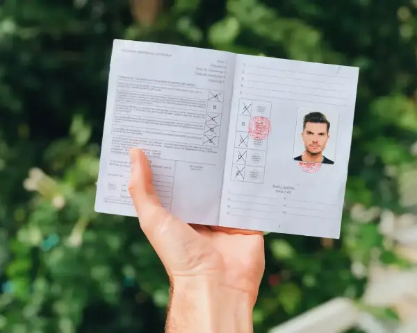Dokument z fotografią i pieczęciami, pokazujący jak wyrobić międzynarodowe prawo jazdy.