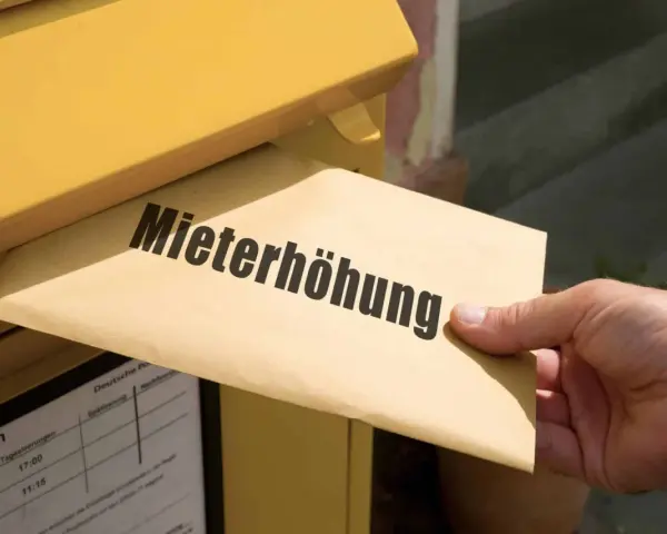 Brief mit "Mieterhöhung" wird in gelben Briefkasten eingeworfen. Wichtige Fristen beachten!