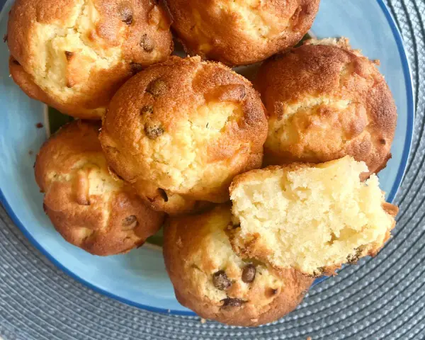 Saftige Apfelmuffins, perfekt für ein schnelles apfelmuffins rezept. Einer ist aufgeschnitten und zeigt die lockere Krume.