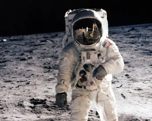 Un astronaute sur la Lune, le 20 juillet 1969. Le reflet dans son casque montre la Terre et d'autres astronautes.