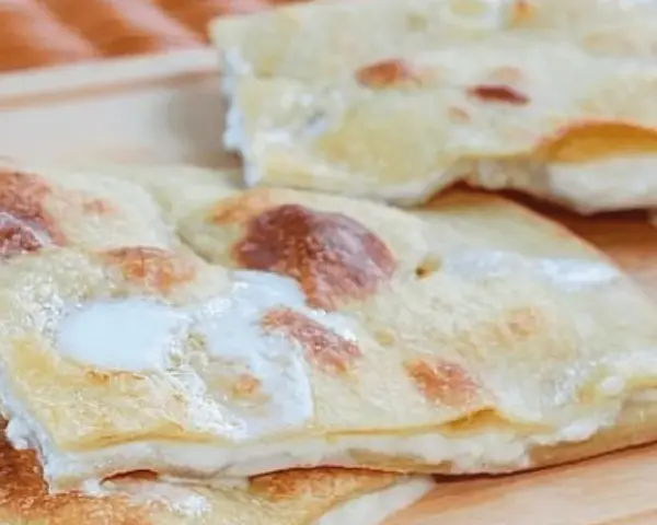 Focaccia di Recco, sottile e dorata, con il suo ripieno filante di formaggio fresco.