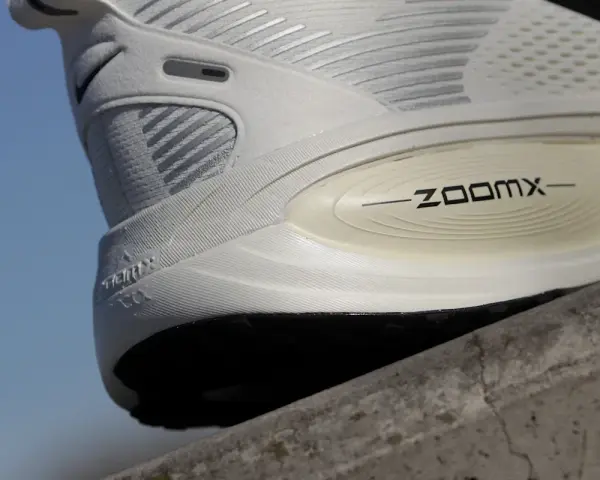 Biały but sportowy z technologią ZoomX. Drop w butach to różnica wysokości między piętą a palcami, kluczowa dla komfortu biegania.